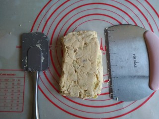 红薯司康饼,倒在案板上，用刮刀和刮板将他压成长方形，切成两半重叠放置