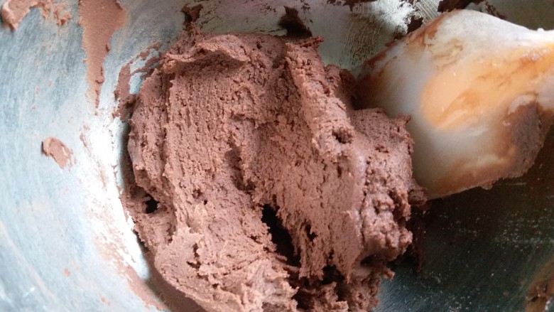 冬天也好挤的巧克力曲奇,用刮刀把面粉 可可粉和黄油霜翻拌均匀。