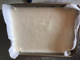 黄金糕,铺好油纸，倒入容器放置温暖的地方进行第一次发酵，期间每隔20分钟用打蛋器搅打一次，发酵大约1小时
