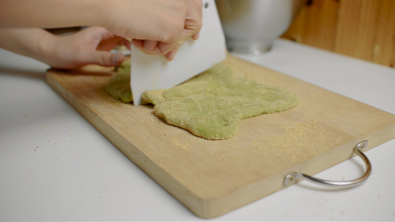厨师机糯米年糕2吃,案板上撒黄豆粉，放上抹茶年糕，表面也撒黄豆粉，分成小份。