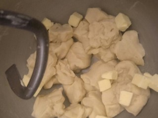 香软手撕椰蓉土司🍞,把面团切成小块，和无盐黄油一起慢慢搅打。