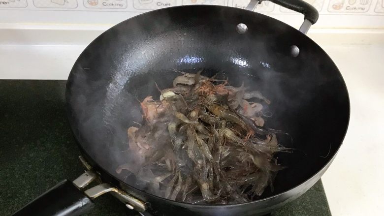 韭菜炒河虾,接着倒入清洗好的河虾。