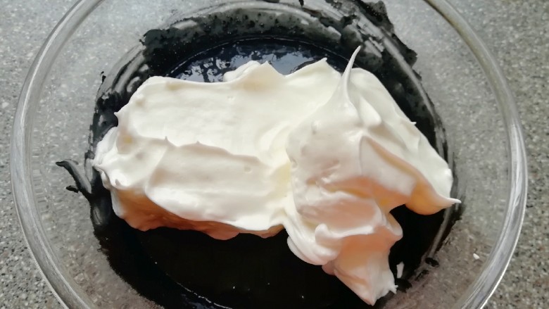 蜂窝煤戚风蛋糕,将打发好的蛋白分成三份，取中间的三分之一加入到蛋黄糊里面，用硅胶刮刀采用切拌和翻拌的方法混合均匀。