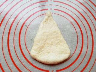 燕麦全麦羊角包,取一份面团整理擀成三角形。