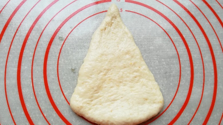 燕麦全麦羊角包,取一份面团整理擀成三角形。