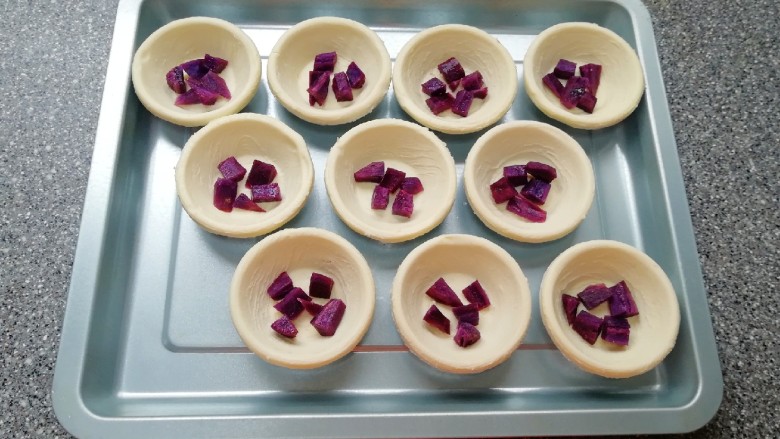 紫薯蛋挞,提前解冻的<a style='color:red;display:inline-block;' href='/shicai/ 4187'>蛋挞皮</a>摆在烤盘里，放上蒸好的紫薯。