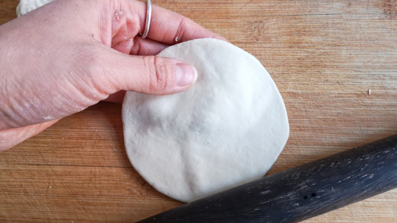 烫面海菜大包,将面剂子按扁擀成中间略厚边缘薄的包子皮。
