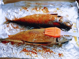 香辣孜然烤鱼,30分钟后戴上隔热手套，将烤盘取出，将鱼的两面刷上食用油，再次送入烤箱中层烤20分钟。



1