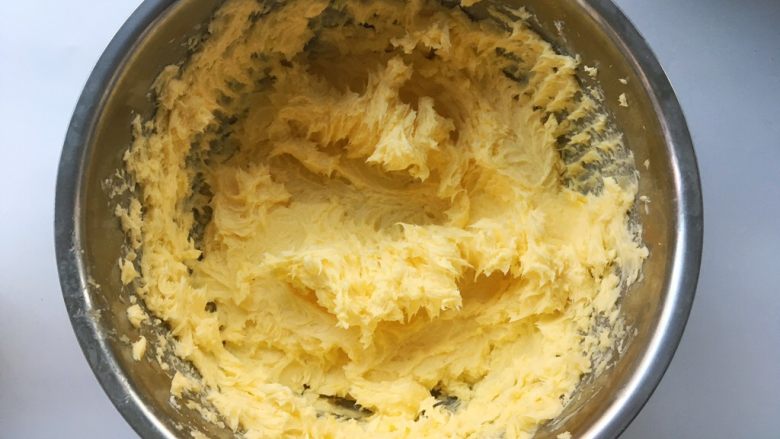 奶香酥脆曲奇,继续打发，将黄油跟淡奶油充分融合，黄油颜色变浅一些