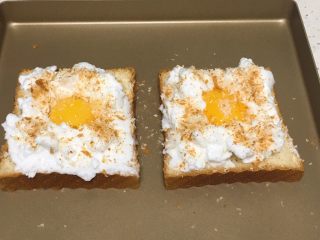 快速早餐吐司片-鸡蛋味,蛋白霜挑入吐司片上，中间留出空间，放入蛋黄，表面撒少许细砂糖，再放一些切吐司片出来的碎隙。