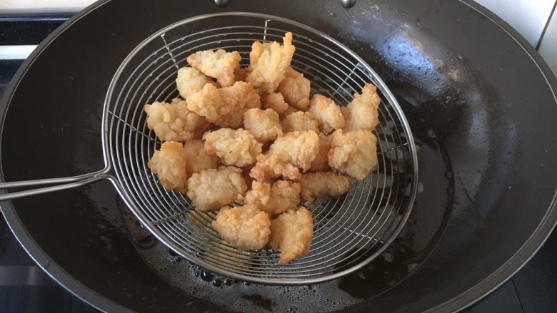 炸椒盐鸡米花,鸡块定型后捞出沥干油份。
