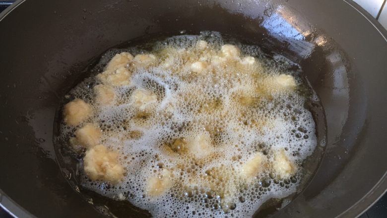 炸椒盐鸡米花,油温5成热时放入小鸡块。
鸡块盐一粒一粒的放入，否则粘在一起。