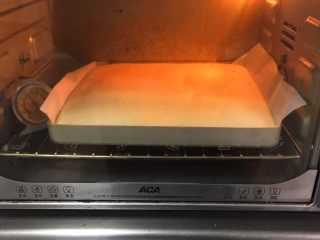 草莓酱蛋糕卷,烤箱预热至150度，金盘送入烤箱，烤制20分钟。
