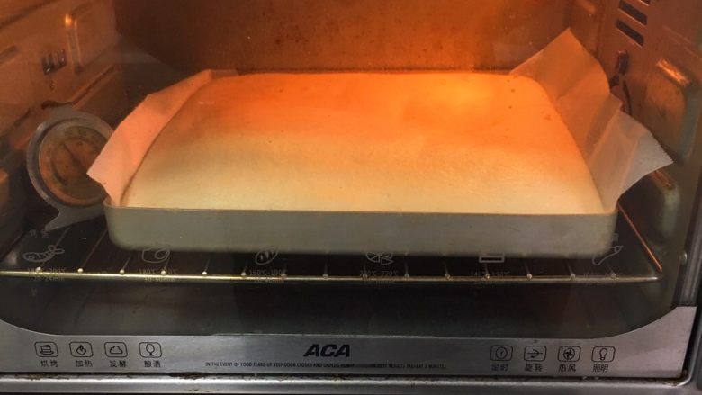草莓酱蛋糕卷,烤箱预热至150度，金盘送入烤箱，烤制20分钟。