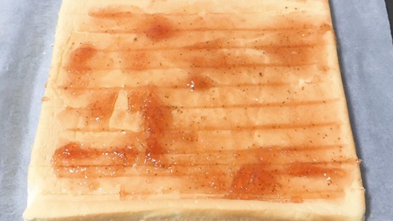 草莓酱蛋糕卷,冷却一下，蛋糕移至烤盘纸上，表面铺上<a style='color:red;display:inline-block;' href='/shicai/ 10736'>草莓果酱</a>，至于放多少可以自由发挥，我的观点是簿簿的一层。