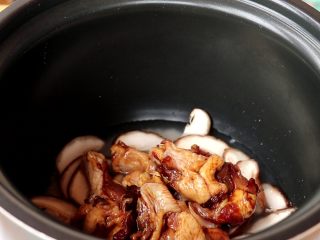 电饭锅焖饭,铺一层香菇，上面放上腌制好的鸡翅根