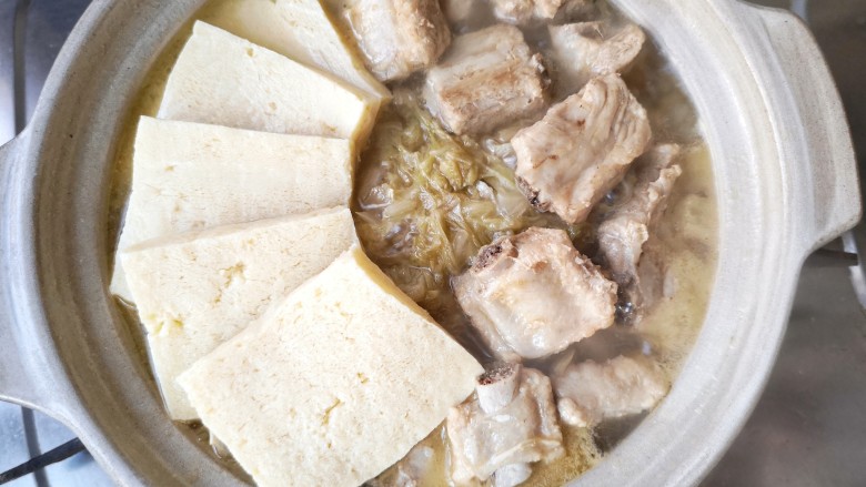 酸菜排骨暖锅,将冻豆腐煮到酸菜排骨锅里，冻豆腐渐渐鼓胀，蜂窝状的纹理中，吸饱了酸香馥郁的汤汁，是整锅的精髓。
