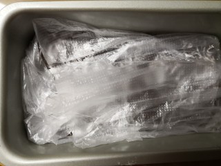 红糖全麦杏仁曲奇,把多出模具外的保鲜膜折回来，包在面团表面。放入冰箱冷藏一小时。