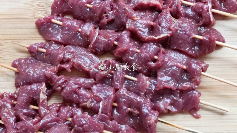 烤牛肉串,腌制好的牛肉片用竹签穿起来。