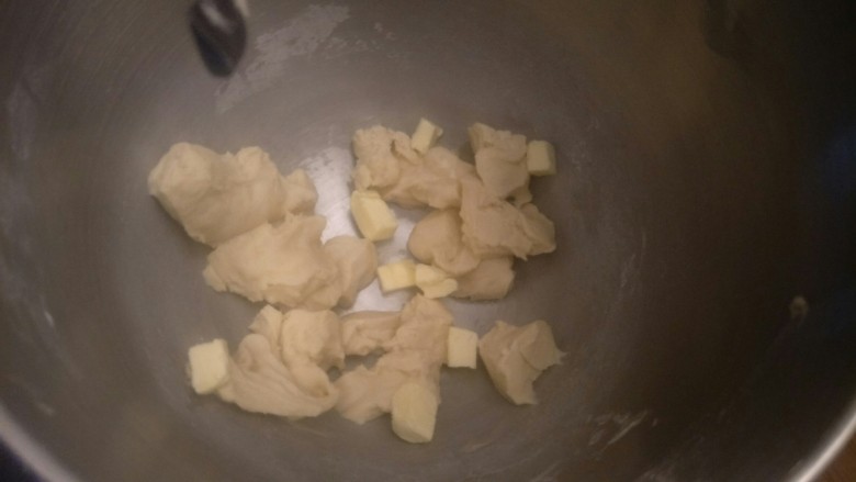 超软豆沙面包圈—家庭手作小点心,把面团切成小份。加入软化好的15克无盐黄油。