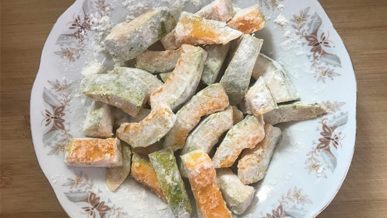 咸蛋黄焗南瓜,把腌好的南瓜块吸干水分，薄薄地裹上一层淀粉。
