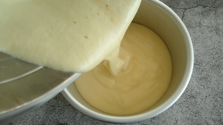 原味戚风蛋糕,把翻拌好的蛋黄糊倒入模具。