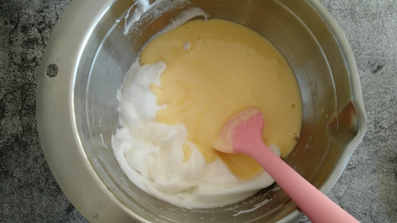 原味戚风蛋糕,把翻拌好的蛋黄糊倒入蛋白中 继续翻拌均匀。