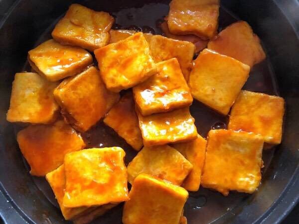 糖醋脆皮豆腐,把调好的糖醋酱汁淋入豆腐上，使每块豆腐都均匀裹上酱汁