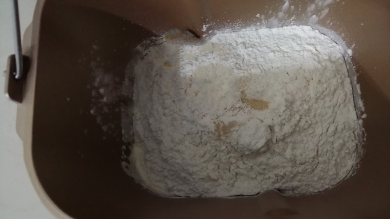 中种醇奶面包卷,倒入250克面粉和两克酵母，面包桶放入到东菱面包机里，选择一个十分钟的和面程序