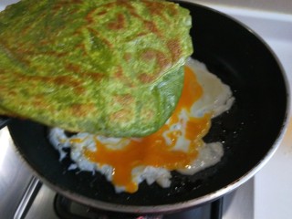 菠菜饼沾鸡蛋,在把菠菜饼沾在鸡蛋上。