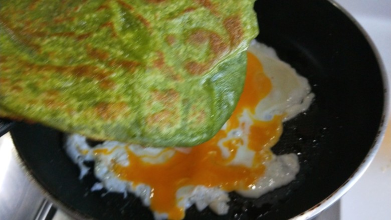 菠菜饼沾鸡蛋,在把菠菜饼沾在鸡蛋上。