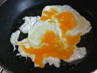 菠菜饼沾鸡蛋,平底锅刷均匀油，打入两颗鸡蛋，蛋黄挑开。