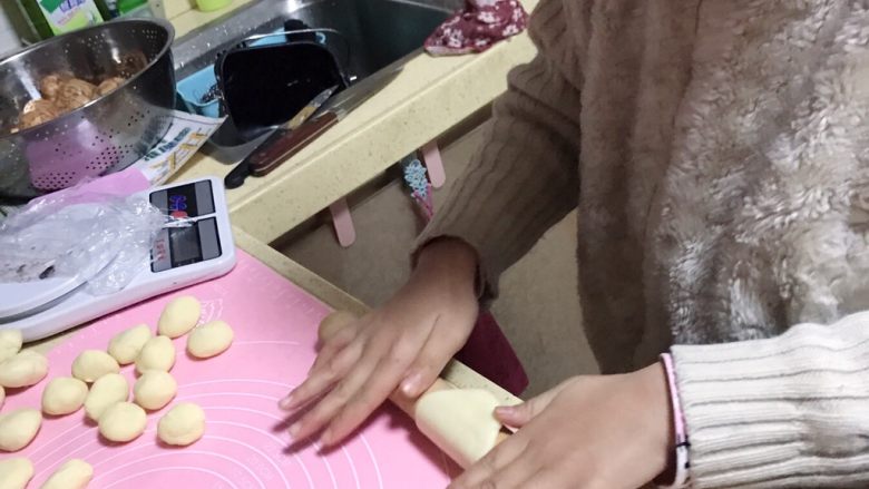 传统中式点心蛋黄酥,将水油皮和油酥滚圆后，把水油皮用擀面杖压扁，女儿亲自上阵，女儿八岁，也能制作。
