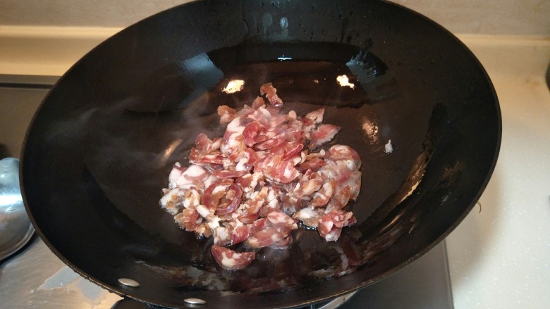猪油腊肠菜饭,把香肠丢进锅里炒制。