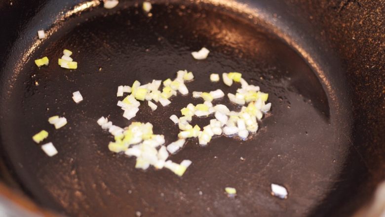 金牌蒜香排骨,把锅里的油倒出来，不用洗锅。放一些葱末，炒香。（爱吃辣的可以在这一步放入一些干辣椒）