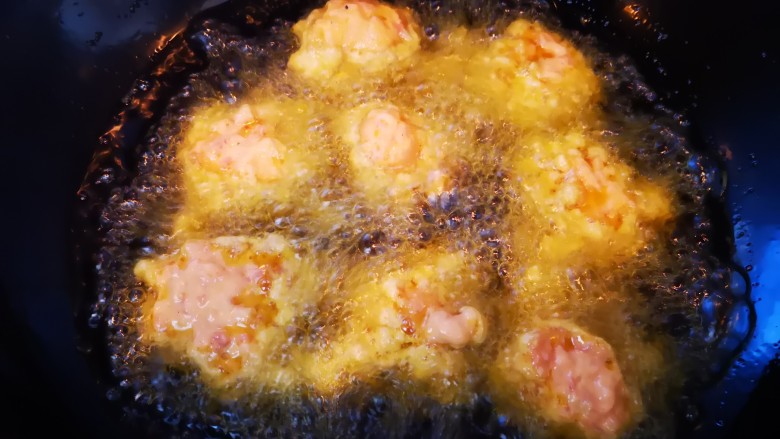 滇味炸酥肉,油锅烧至七成热，用勺将搅拌好的肉糊舀入油锅中，进行小火炸制并不断用筷子翻面