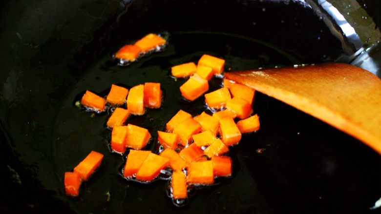 补钙补血的芹菜虾仁炒饭,重新起锅烧热后，倒入剩下的40克花生油烧至六成热时，先放入胡萝卜丁小火煸炒。