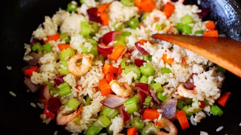 补钙补血的芹菜虾仁炒饭,用锅铲把米饭打散后，继续翻炒片刻。
