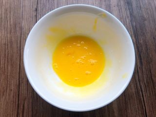 芒果酥,把蛋黄打入碗里，用筷子搅打均匀。