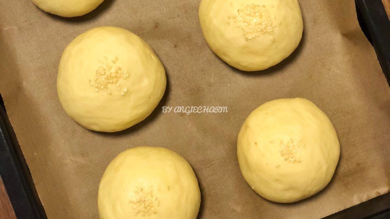无油陈皮红豆馅小面包,大概40～60分钟后，面团肉眼可见膨胀了，用手指轻轻按压，指印慢慢恢复一部分，这时可以预热烤箱了。还可以在面团表面喷一点点水，撒上芝麻。