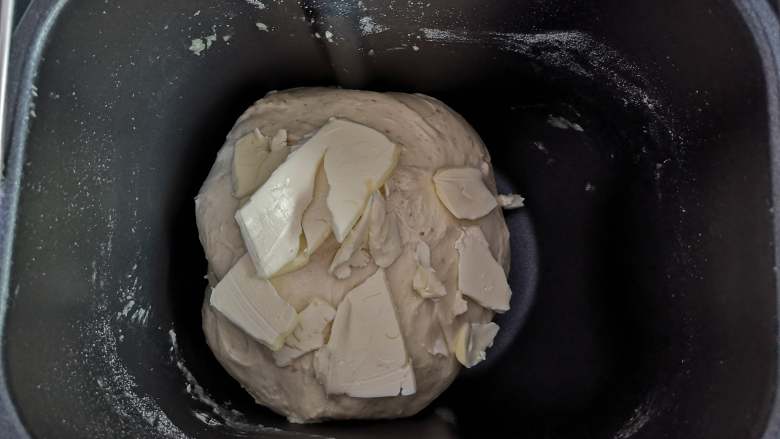 美味看得见的红薯吐司,面团变得光滑，能拉出膜时，加入切成小块的黄油，继续揉面。面团会越来越光滑，拉出的薄膜变得结实时，将面团取出。
