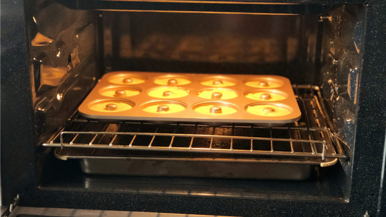 柠檬玛德琳甜甜圈,把模具放到预热好的烤箱里。
