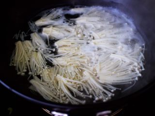 养胃益气的番茄酸汤肥牛卷,锅中加入适量的清水烧开，把金针菇放入锅中，大火煮1分钟捞出备用。