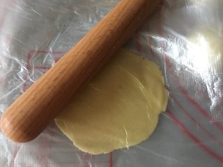 港式酥皮菠萝包,取小油酥面团放入保鲜膜上，上面再盖一层，用擀面杖擀成薄薄的圆面片
