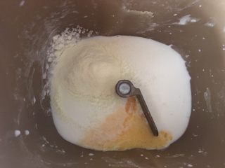 港式酥皮菠萝包,先将牛奶、鸡蛋液、白糖、奶粉、盐倒入面包机