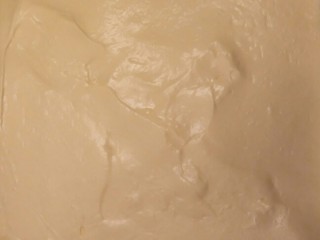 细腻顺滑的法式淡奶油蛋糕卷,用刮刀铺满烤盘。