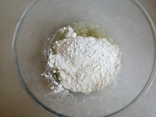 古早味蛋糕,将加热后的玉米油倒入盆里，再将面粉过筛倒入