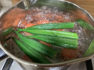 面线虾烤肠彩蔬便当盒,沸水煮熟胡萝卜和秋葵。