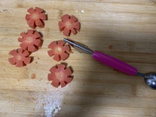 面线虾烤肠彩蔬便当盒,胡萝卜切片，再用刀切成花朵状。