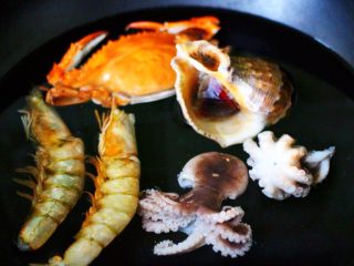 过年必备的海鲜什锦全家福,锅中倒入适量的清水，把洗净的对虾和桃花蛸，梭子蟹和海螺都放入锅中。